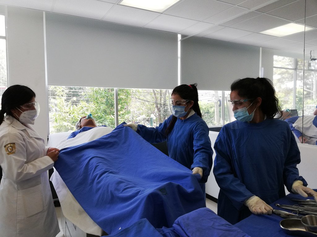 Estudiantes de enfermería y obstetricia practican la asistencia al parto con un maniquí.