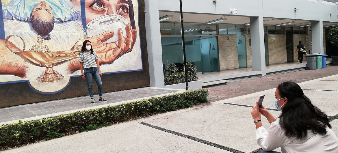 Students posing in front of the mural 