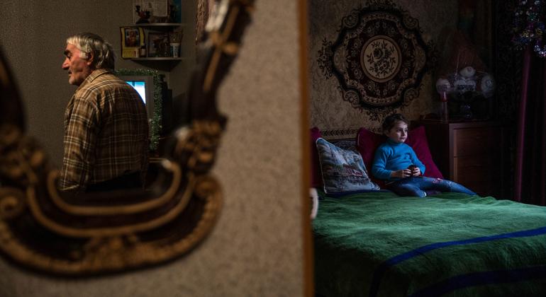 Abel observe sa petite-fille, Barbara, à l’intérieur de leur maison dans la camp de personnes déplacées de Tserovani, en République de Géorgie. Barbara est née dans le déplacement. 