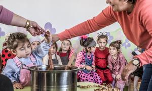 Les élèves de maternelle préparent la chorchella, une collation géorgienne traditionnelle de pâte de raisin et de noix, lors d’une célébration automnale dans la colonie de Tsilkani.