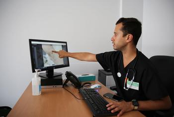 在葡萄牙里斯本的一家性健康诊所，一名医生在电脑屏幕上查看猴痘病变的图像。