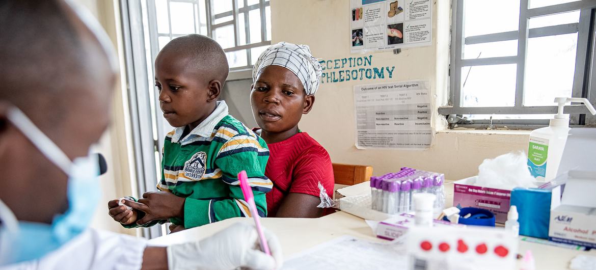 أم وابنها البالغ من العمر تسع سنوات، وكلاهما مصاب بفيروس نقص المناعة البشرية، يزوران عيادة صحية في موبيندي، أوغندا.