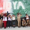 أطفال يشاركون في ورشة تصوير في ليبيا، يلتقطون الصور أمام جدارية في طرابلس. (من الأرشيف)
