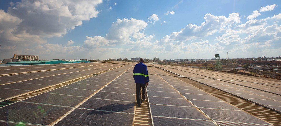 Un technicien s'occupe de panneaux solaires sur le toit d'un entrepôt à Lusaka, en Zambie.