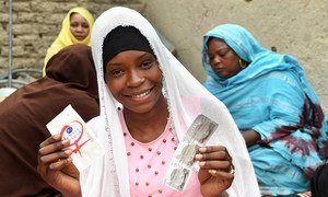 In the center of Chad, 19-year-old Achta holds up condoms during an HIV awareness-raising session in her Moussoro community. (March 2019)