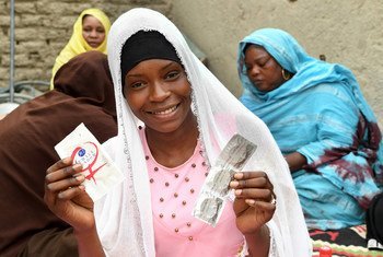 In the center of Chad, 19-year-old Achta holds up condoms during an HIV awareness-raising session in her Moussoro community. (March 2019)