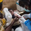 काँगो लोकतान्त्रिक गणराज्य के उत्तर कीवू प्रान्त में एक नर्स एक शिशु का नियमित टीकाकरण करते हुए.