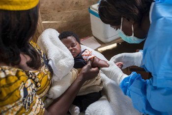 Una enfermera se prepara para vacunar a una niño contra el sarampión en la RD Congo.