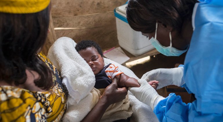 Una enfermera se prepara para vacunar a una niño contra el sarampión en la RD Congo.