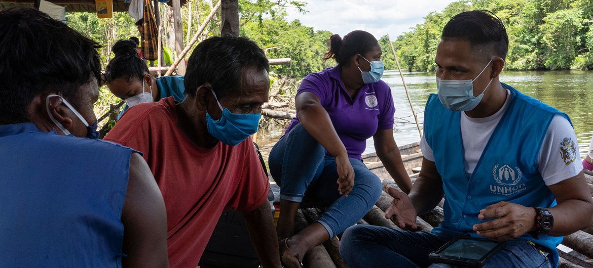 UNHCR staff assess the needs of indigenous Warao families from Venezuela living in informal settlements along the banks of a river in Guyana.
