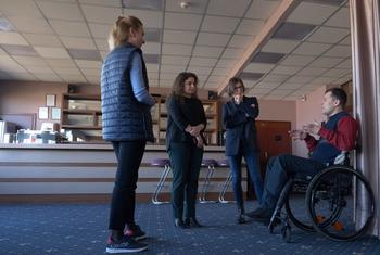 A specialist from the UN Development Fund (UNDP) meets in Ukraine with a person with disabilities and others.