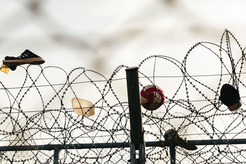 Des chaussures, une balle et un chapeau accrochés à une clôture en barbelés au centre d'accueil et d'identification de Fylakio près de la frontière gréco-turque.