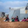 أطفال يجلسون خارج خيمة الأسرة في مخيم الزهرية  في شرق ريف حمص، سوريا.