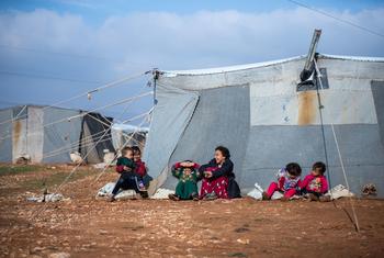 Children sit outside their family tent at the Alzhouriyeh makeshift camp in east rural Homs, Syria.