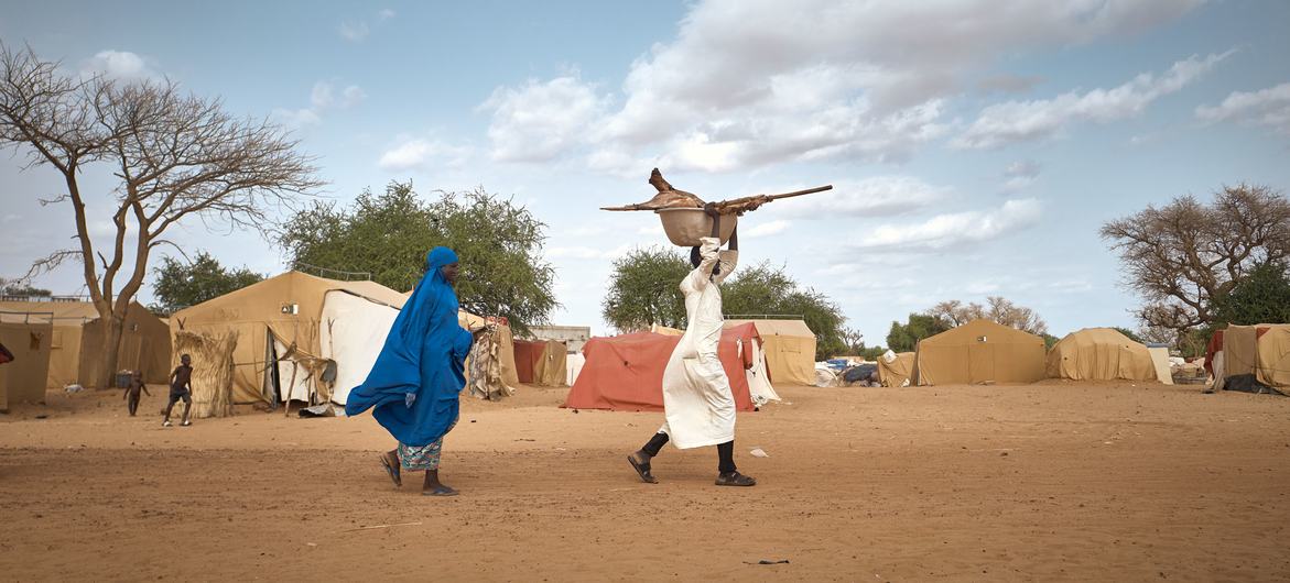 زوجان يحملان اللحوم إلى خيمتهما خلال يوم تاباسكي في مخيم للنازحين في النيجر.