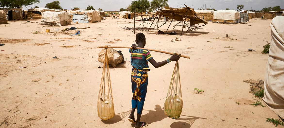 شابة تنقل الماء في أحد مخيمات النازحين في إقليم تيلابيري، النيجر.