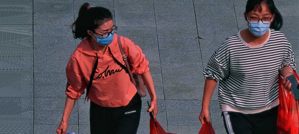 Dos mujeres en Shenzhen, China, de camino al trabajo en medio de la epidemia del coronavirus. 