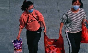 Dos mujeres en Shenzhen, China, de camino al trabajo en medio de la epidemia del coronavirus. 