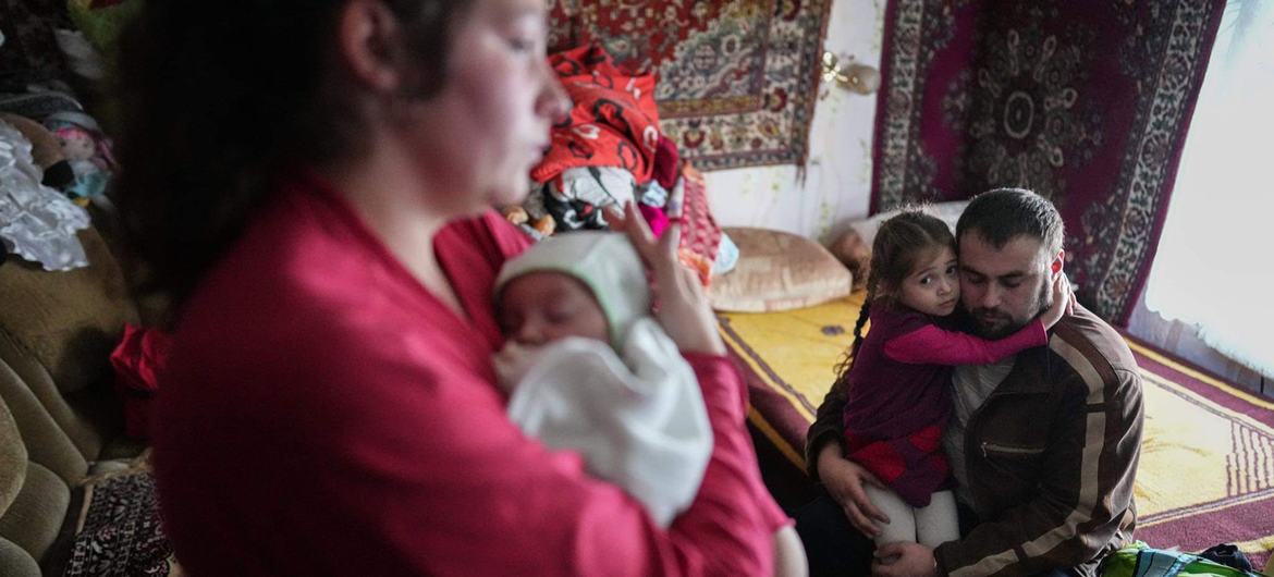 Los padres de una niña de cuatro años y un bebé de dos meses consolando a sus hijos tras un bombardeo de las fuerzas separatistas en Novognativka, en el este de Ucrania.