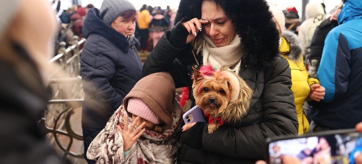 Una familia esperando a subir a un tren de evacuación en Lviv, en el extremo occidental de Ucrania, cerca de la frontera con Polonia.