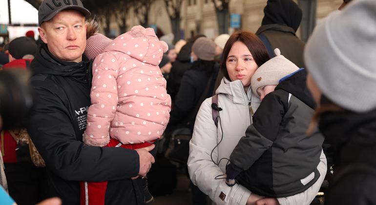 Família ucraniana espera para entrar em trem em estação em Lviv, próximo à fronteira com a Polônia. 