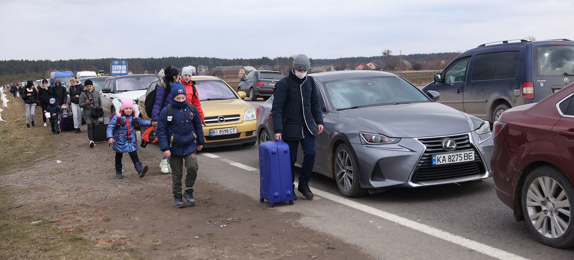 On February 27, 2022, as military operations resumed, people fleeing Ukraine walked along vehicles lined up to cross the border from Ukraine to Poland.