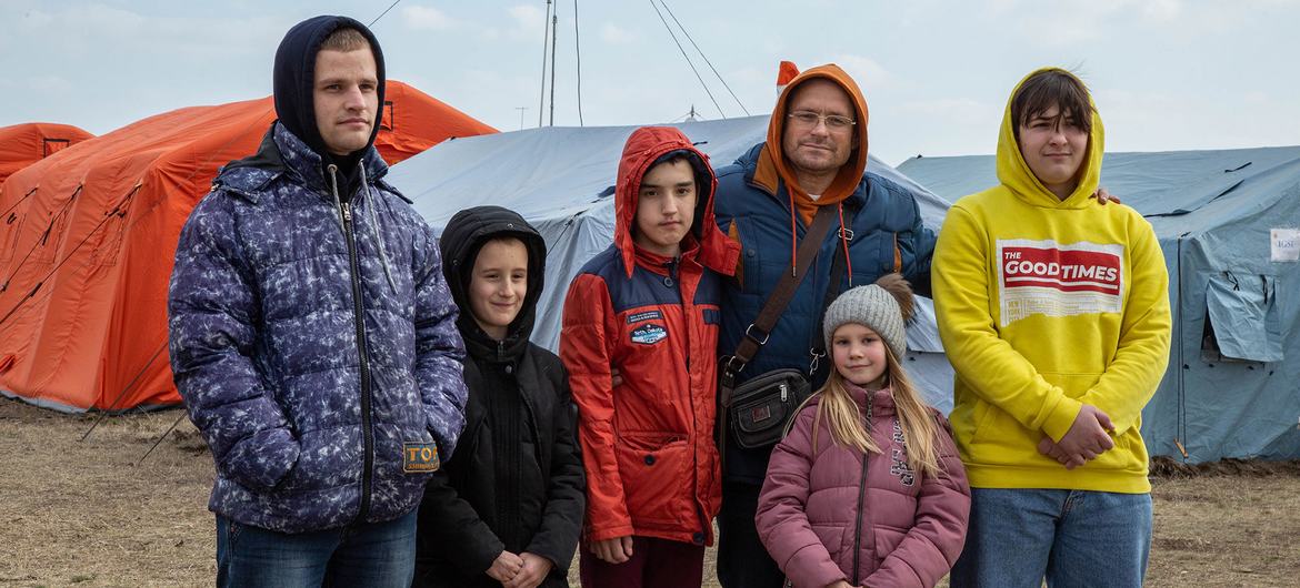 मोल्दोवा और यूक्रेन की सीमा पर स्थित एक अस्थाई शरणार्थी केंद्र में एक परिवार. 