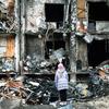 2022 年 2 月 25 日，乌克兰基辅，一名女孩看着一座公寓楼前爆炸留下的残垣断壁，这所公寓楼在正在进行的军事行动中遭到严重破坏。