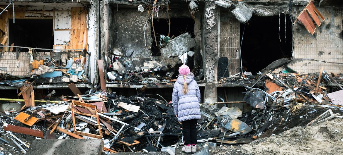 यूक्रेन की राजधानी कीयेफ़ में एक लड़की अपनी अपार्टमेंट इमारत के बाहर है, जोकि बमबारी में ध्वस्त हो गई है. 25 फ़रवरी 2022.