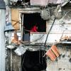 Une femme s'efforce de dégager les débris de son appartement après que le bâtiment ait été lourdement endommagé pendant les opérations militaires en cours à Kyïv, en Ukraine