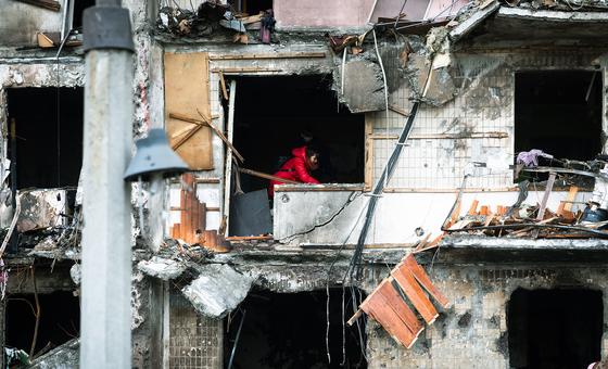 Женщина пытается найти что-то под завалами в своей квартире многоэтажного дома, разрушенного во время продолжающихся военных действий в Киеве, Украина.