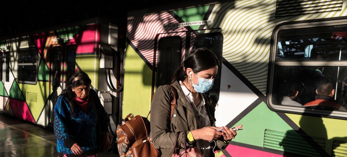 Dos mujeres en el tren de la Ciudad de México se protegen del coronavirus con mascarillas.