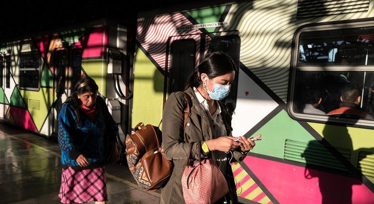 Dos mujeres en el tren de la Ciudad de México se protegen del coronavirus con mascarillas.