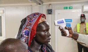 Integrante de un equipo médico mide la temperatura de una mujer desplazada en Sudán del Sur. 
