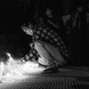 缅甸仰光，一名年轻男子在守夜期间点燃蜡烛。