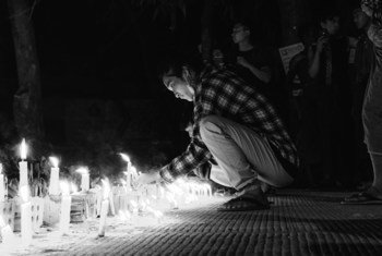 缅甸仰光，一名年轻男子在守夜期间点燃蜡烛。
