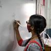 भारत के गुजरात में एक 13 वर्षीय लड़की, गणित का एक सवाल हल करते हुए.