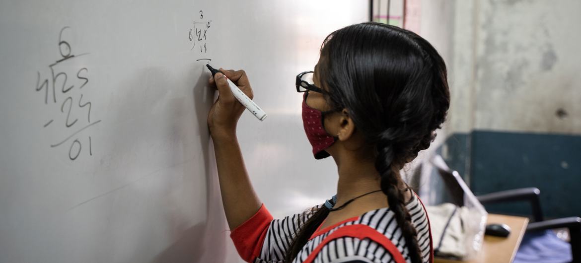 Una niña de 13 años resuelve una suma matemática en una escuela de Gujarat, India