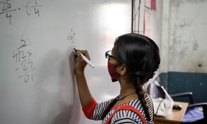 Una niña de 13 años resuelve una suma matemática en una escuela de Gujarat, India