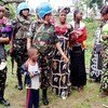 来自坦桑尼亚的女性维和人员与刚果民主共和国贝尼地区的妇女和儿童在一起。