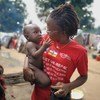 Reporter et animatrice centrafricaine de Guira FM, Merveille Noella Mada-Yayoro tient un enfant dans le camp de déplacés de Birao.
