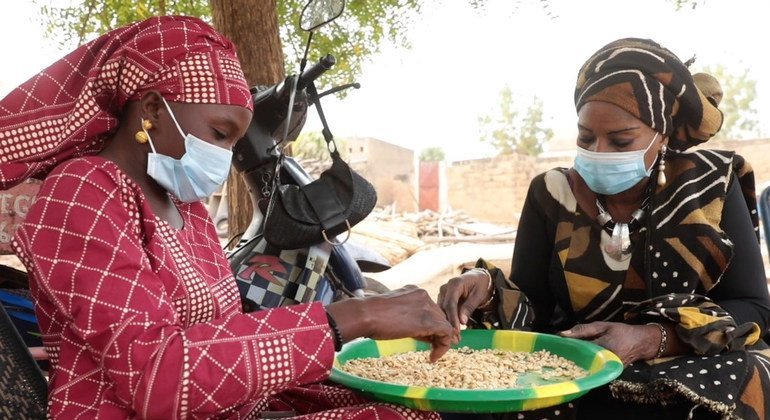 يتم تدريب النساء على صنع معجون الفول السوداني.