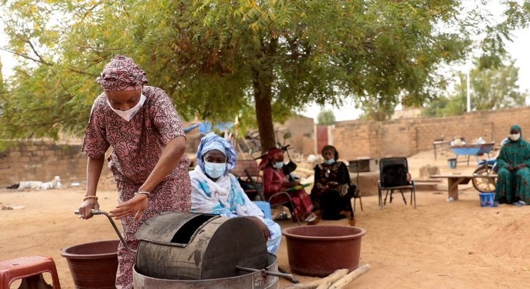 يتم تدريب النساء على صنع معجون الفول السوداني.