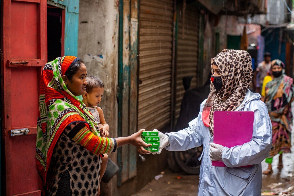 A Dhaka, la capitale du Bangladesh, une agente de santé distribue des fournitures d'hygiène à une famille