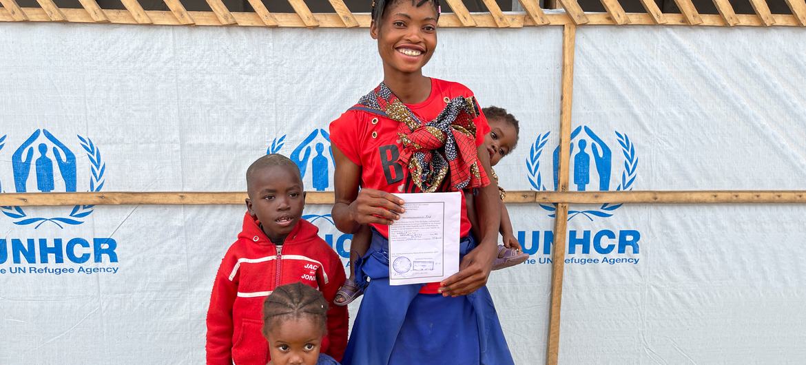 Une mère et ses trois enfants dans un centre de transit à Pweto, en République démocratique du Congo. Elle est contente de retourner chez elle.
