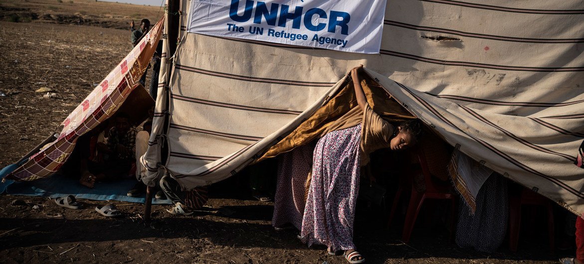 A young Ethiopian refugee looks out from a makeshift shelter at a transit site in Hamdayet, Sudan.