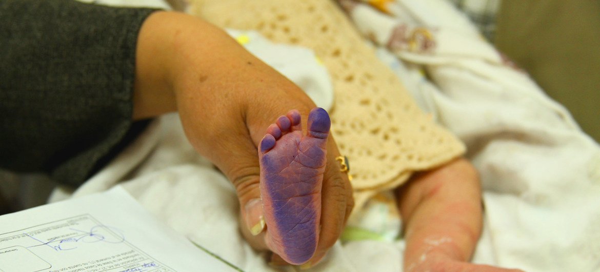 موظفة تسجل بصمة لمولود حديث الولادة على مخطط في مكتب تسجيل مستشفى الولادة في لاباز، بوليفيا.