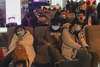 Personas con tapabocas para protegerse del coronavirus esperan para salir del Aeropuerto Internacional de Shenzhen Bao en China. 