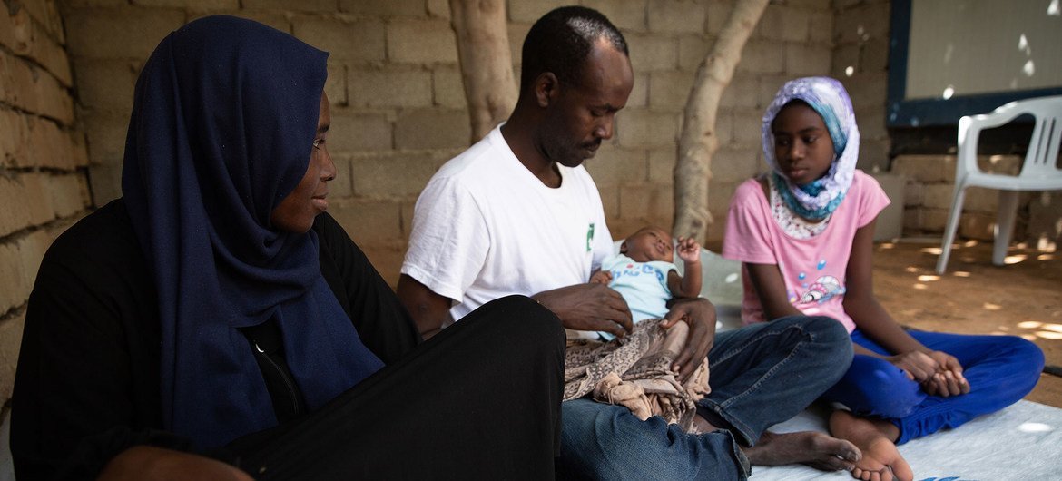 Abdulmajeed and wife Halima, Sudanese refugees from Darfur, sit with their two daughters at home in Tripoli, Libya.