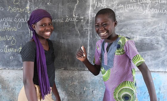 Two young students in Bol, Chad show their work on a blackboard at school.